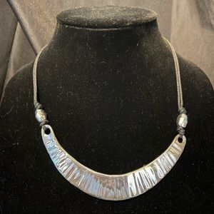 Silver tone necklace on rope chain